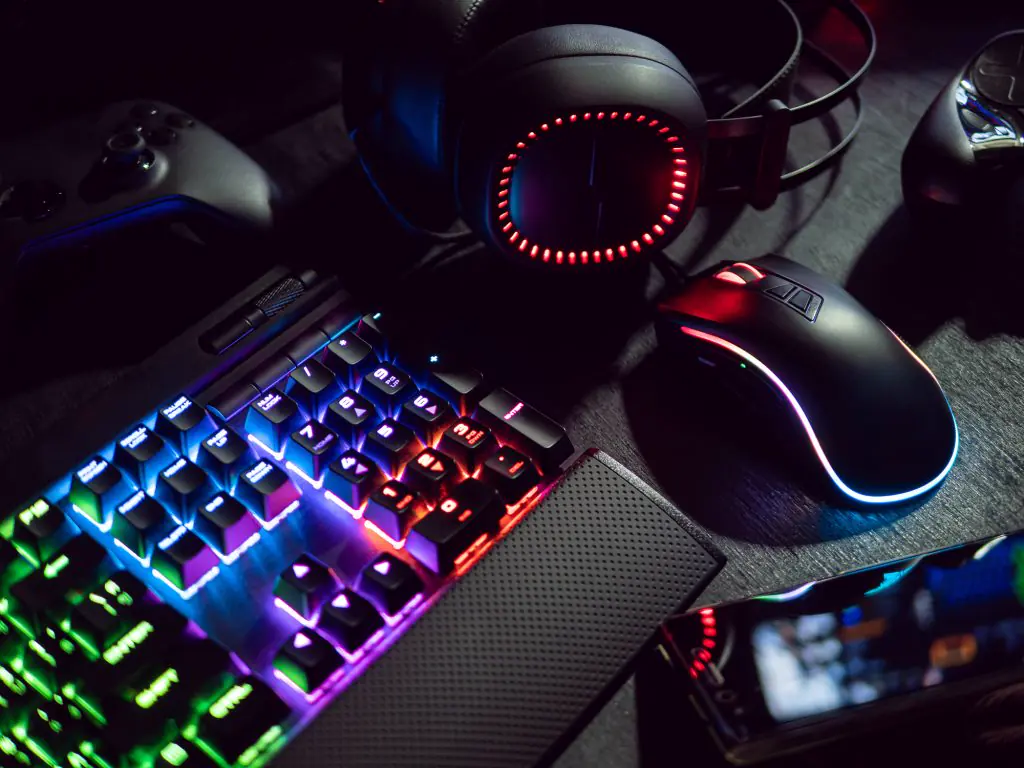 Tastatur, Maus, Headset und Gamepad in dunkler Umgebung
